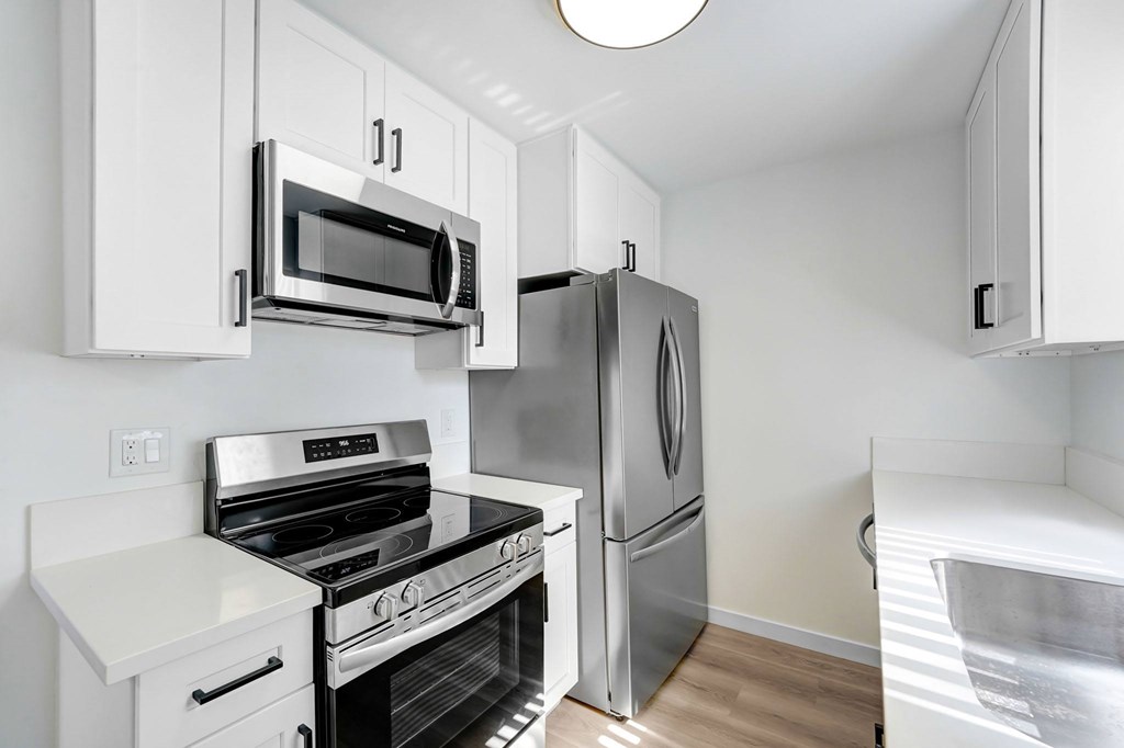 A kitchen with white cabinets and stainless steel appliances.
