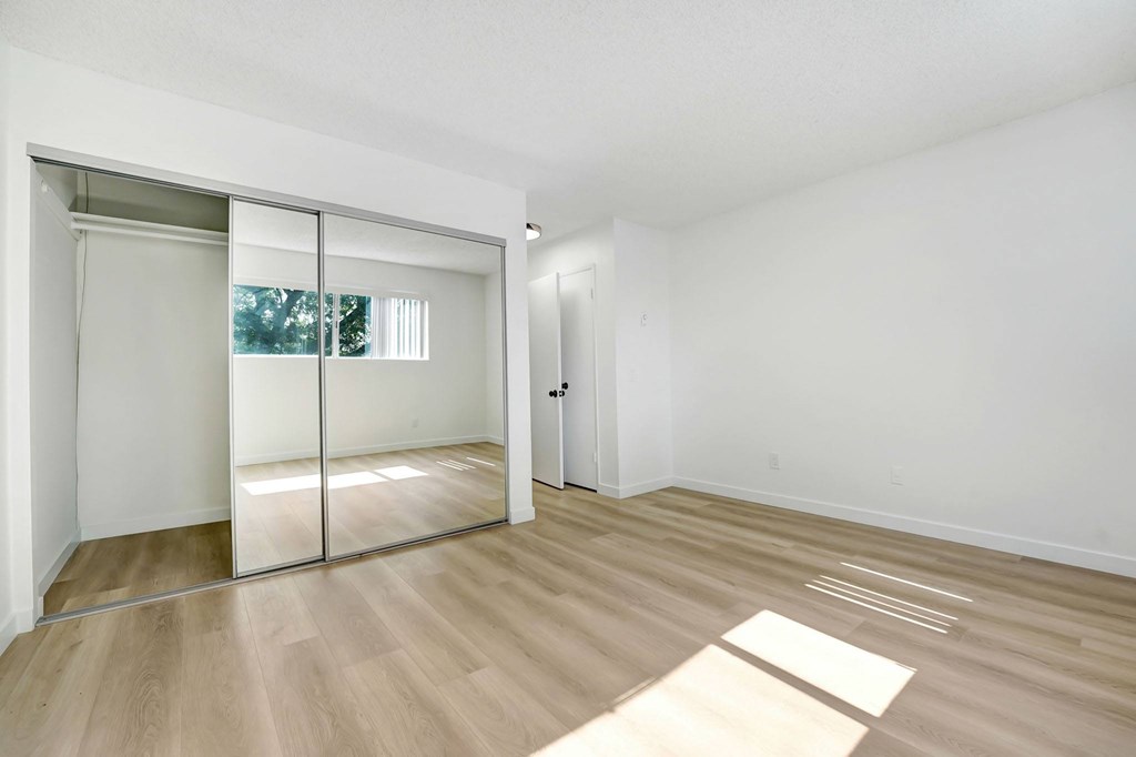 A room with a sliding door and wooden flooring.