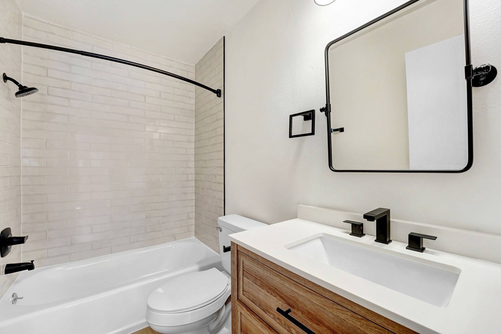 A white bathroom with a white tub and sink.