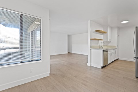 A kitchen with white cabinets and a wooden floor.
