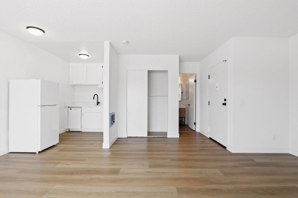 A white kitchen with wood floors and white walls.
