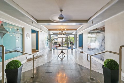 A long hallway with a table and chairs in the middle.