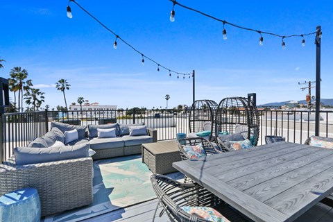 A patio with a table, chairs, and a pool.