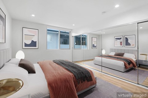 A modern bedroom with a large bed and a glass walled room.