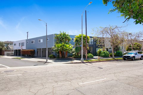 A street view of a residential area with houses and parked cars.