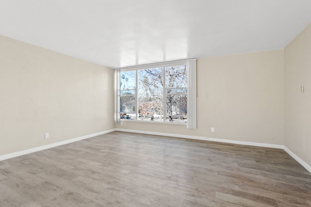 the living room of an empty house with a large window