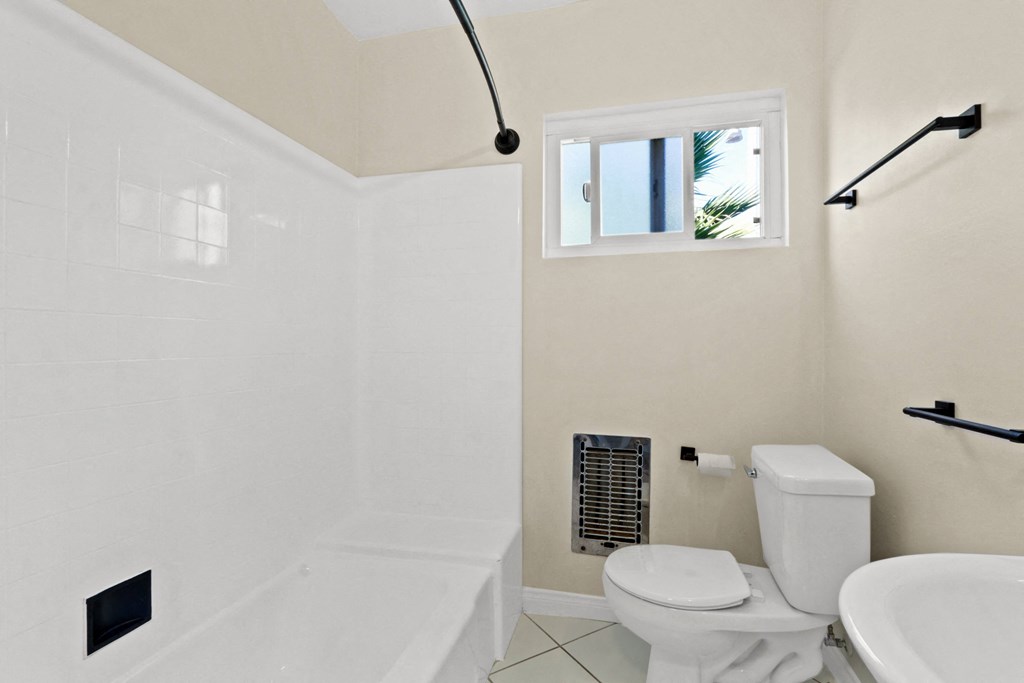 a bathroom with a toilet and a tub and a sink