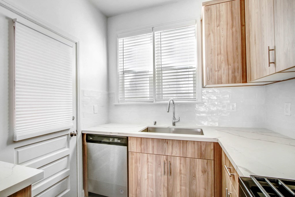 a small kitchen with wooden cabinets and a sink