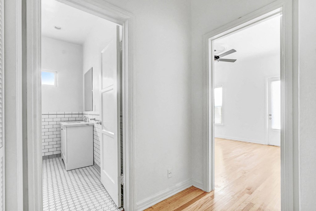 an open door leading into a bathroom and a kitchen