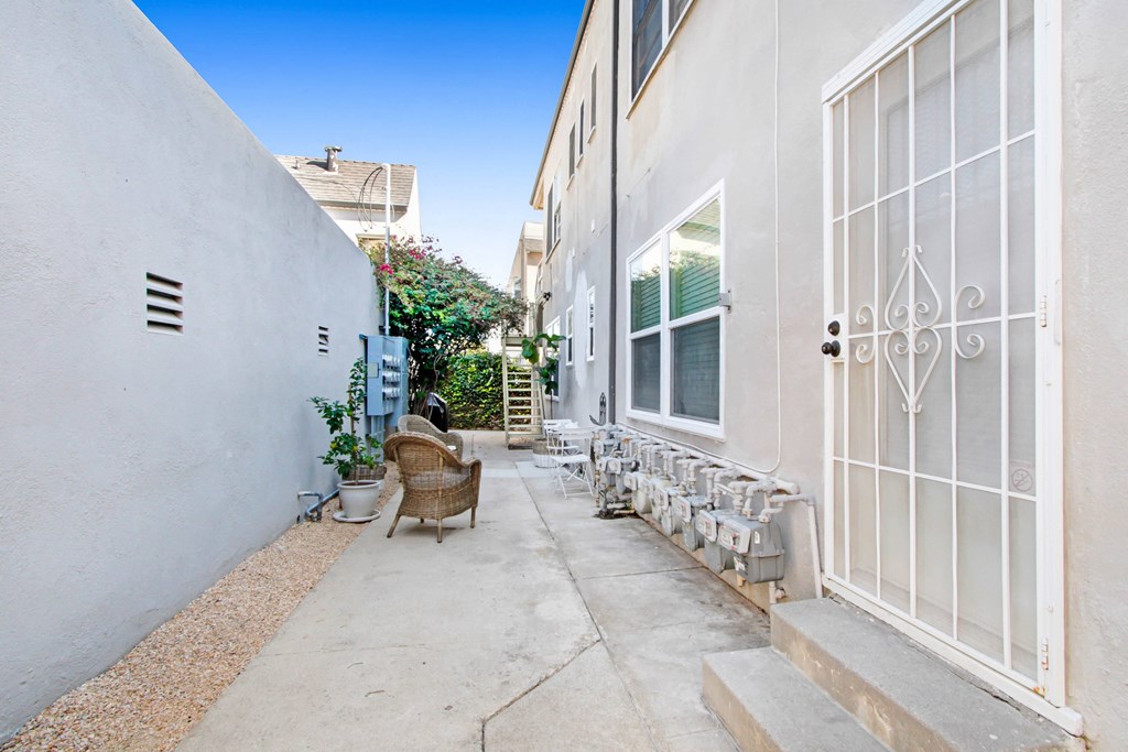 a patio with chairs and a door to a building