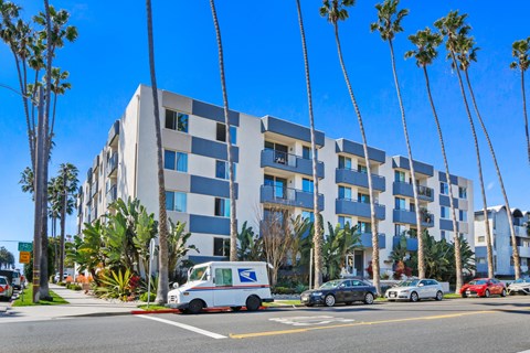 A blue and white building with a USPS van parked in front.