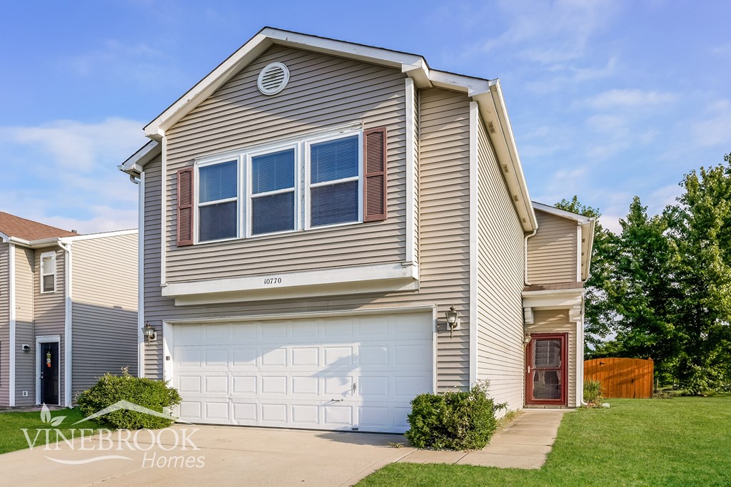 A two-story house with a garage is for sale.