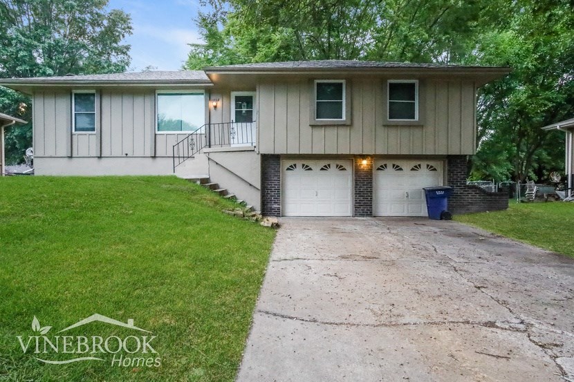 a white house with two garage doors and a driveway