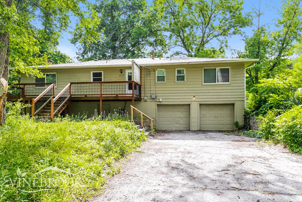 a house with two garage doors and a gravel driveway