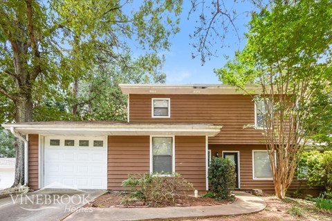 a small brown house with a white garage door