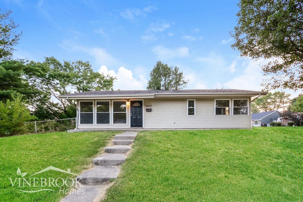 a small white house on a grassy hill with steps