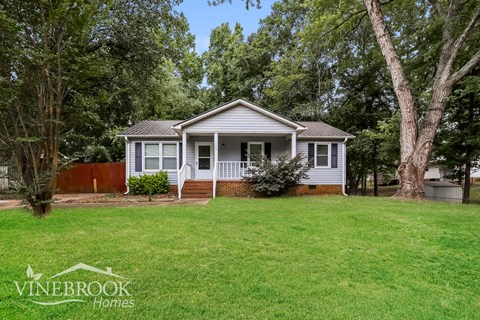 a small white house with a yard in front of it