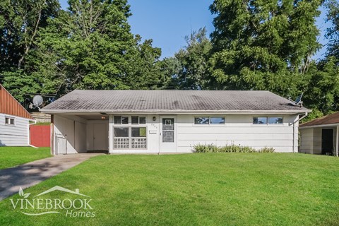 a white garage with a green lawn in front of it