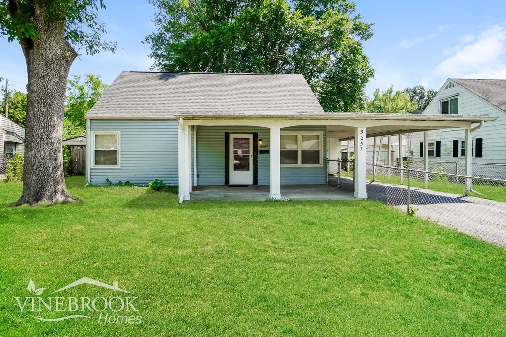 a blue house with a porch and a grassy yard