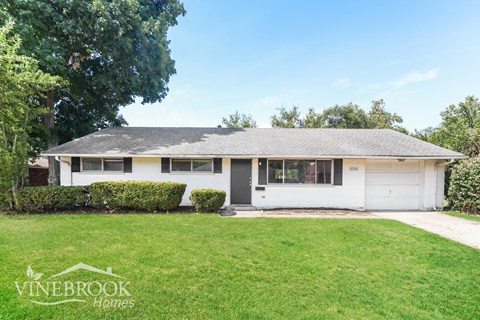 a white bungalow with a lawn in front of it