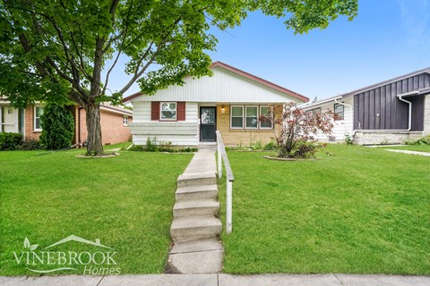 the front of a house with stairs leading up to it