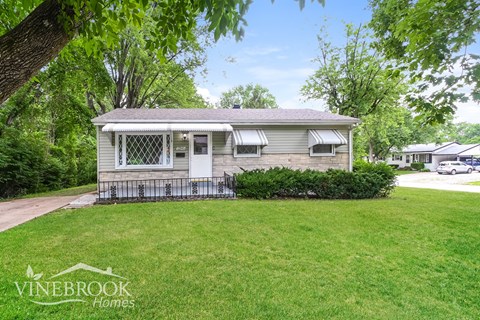a small bungalow with a yard and a porch