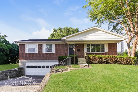 a brick house with a white garage door and a lawn