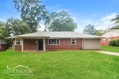 A house with a lawn in front and a sign that says Vinebrook Homes.