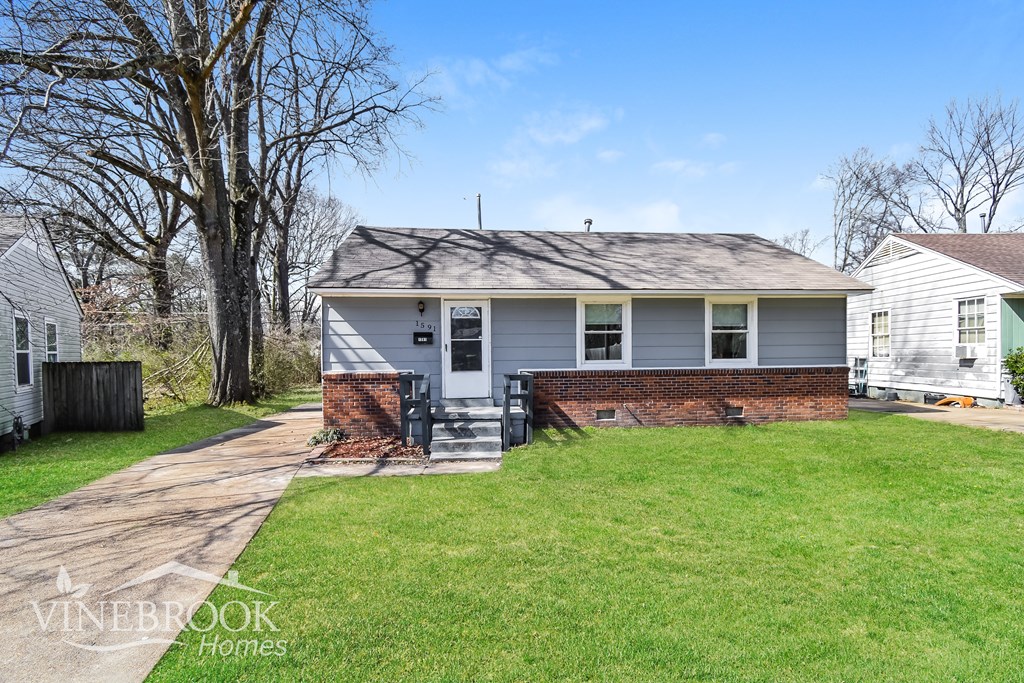 A house with a white fence and a tree in front of it.