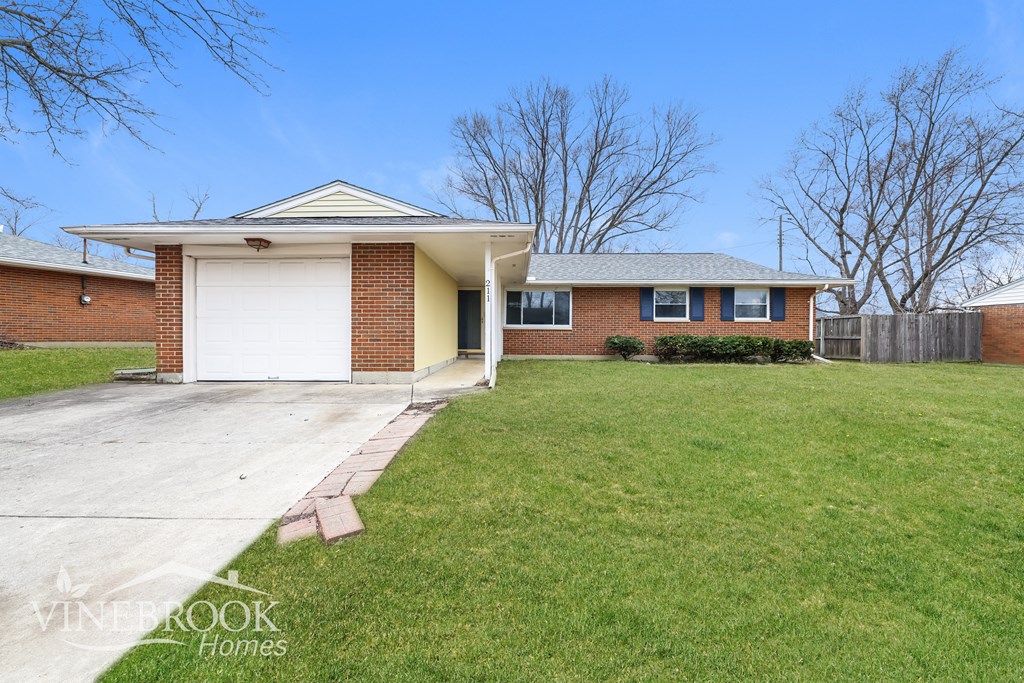 A house with a garage and a lawn in front.