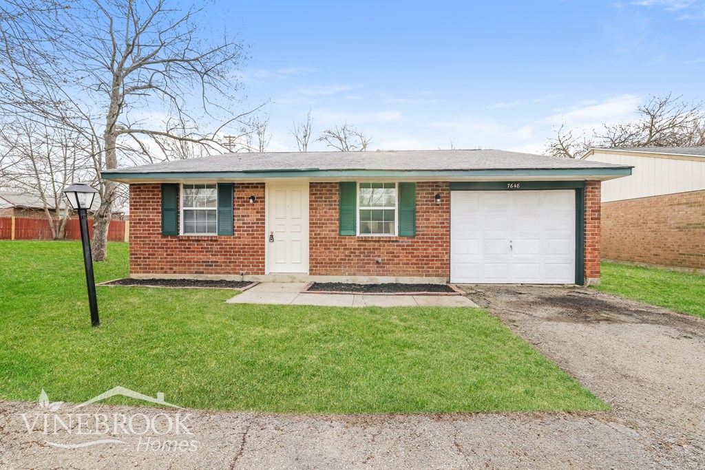 A house with a green lawn and a white garage door.