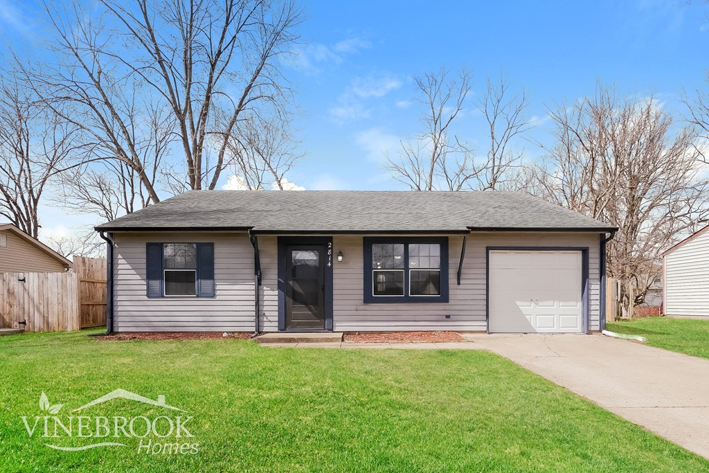 A Vinebrook Homes house with a grey roof and a black garage door.