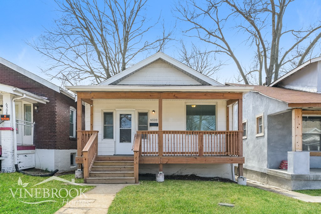 A house with a porch and a sign that says Vinebrook Homes.