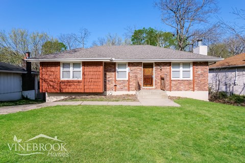 A brick house with a Vinebrook Homes logo in the corner.