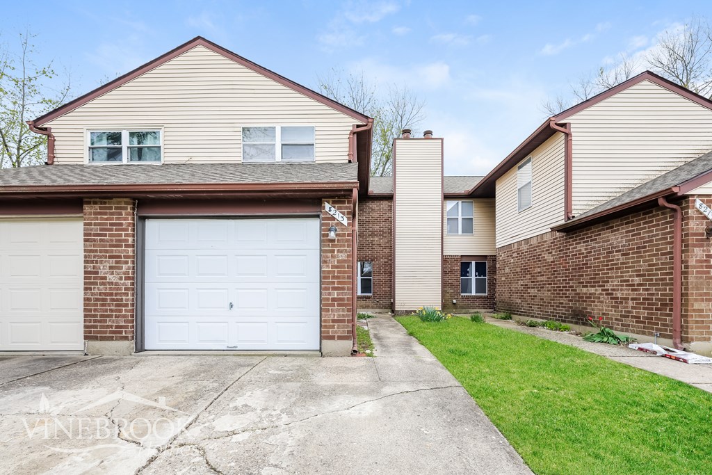 A house with a garage and a driveway in front.