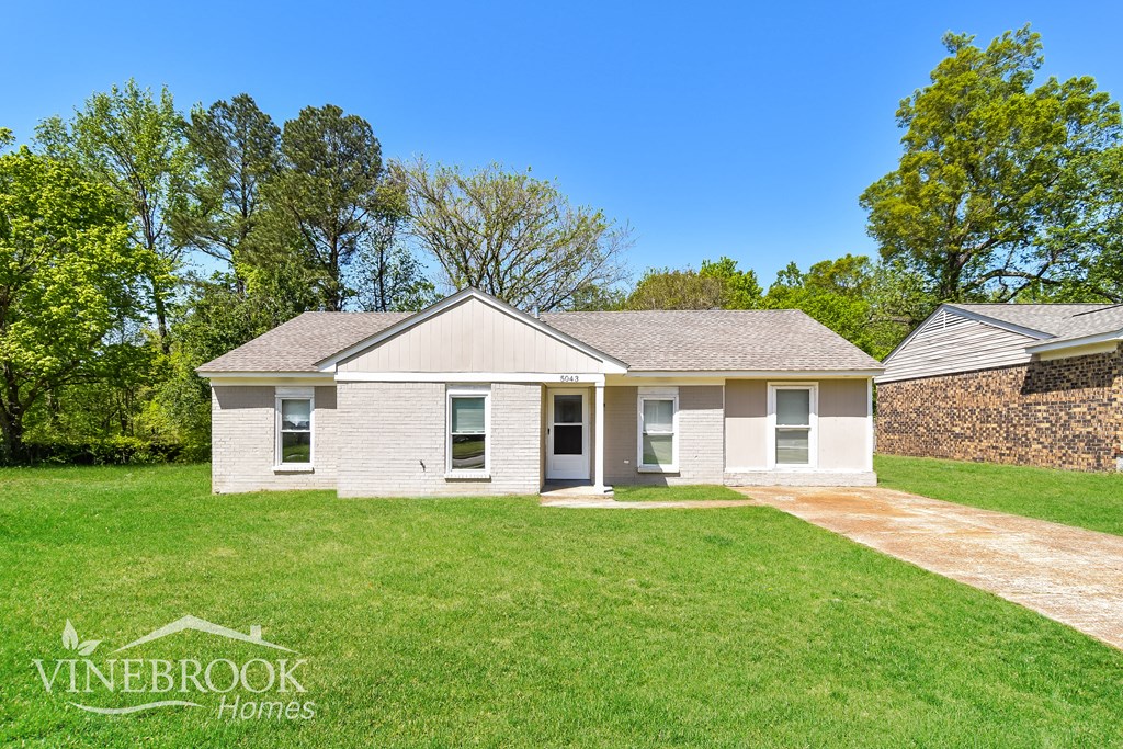 A house with a lawn in front of it and a sign that says Vinebrook Homes.