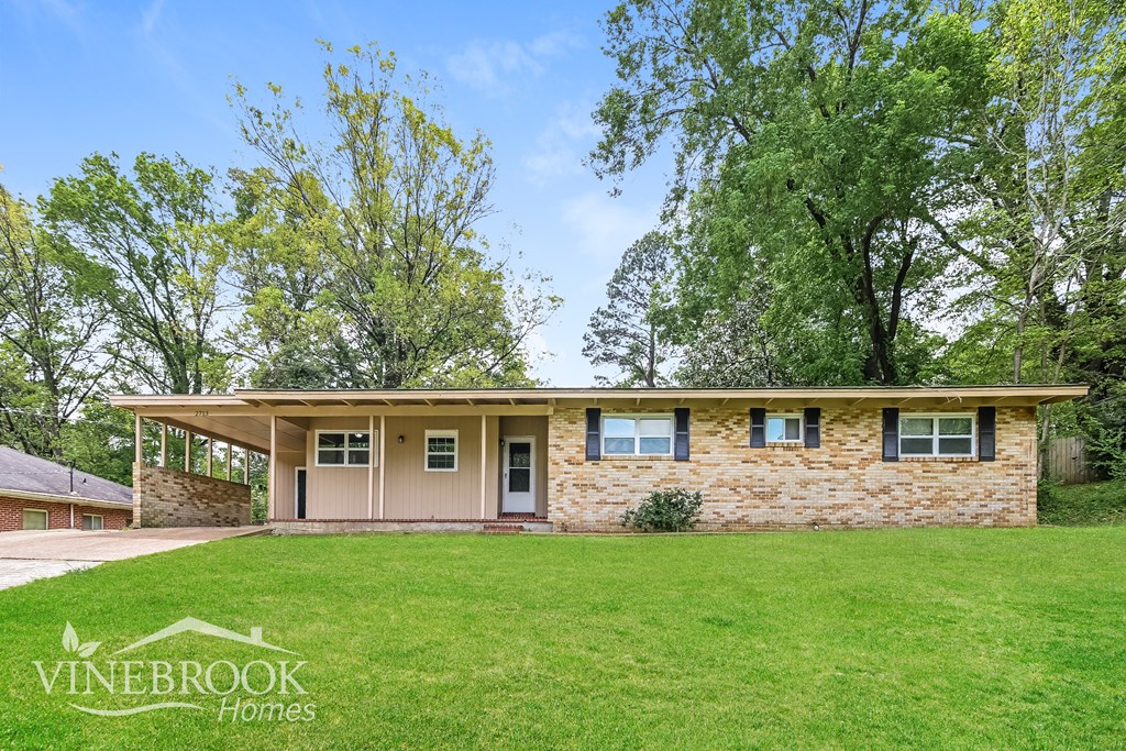 A house with a lawn in front of it and a sign that says Vinebrook Homes.