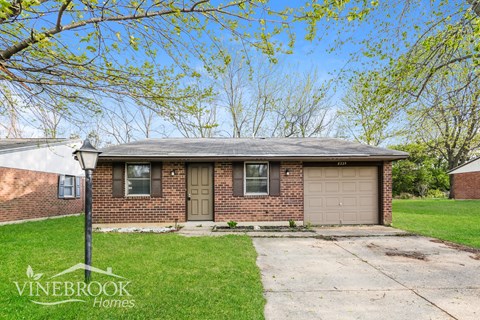 A Vinebrook Homes sign is in front of a brick house.