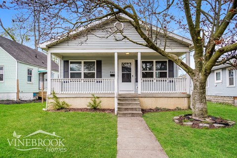 A Vinebrook Homes house with a front porch and a tree.
