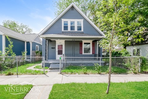 A house with a red door and a sign that says Vinebrook Homes.