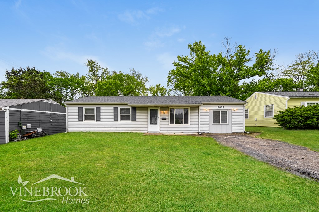 A house with a lawn in front of it and a sign that says Vinebrook Homes.