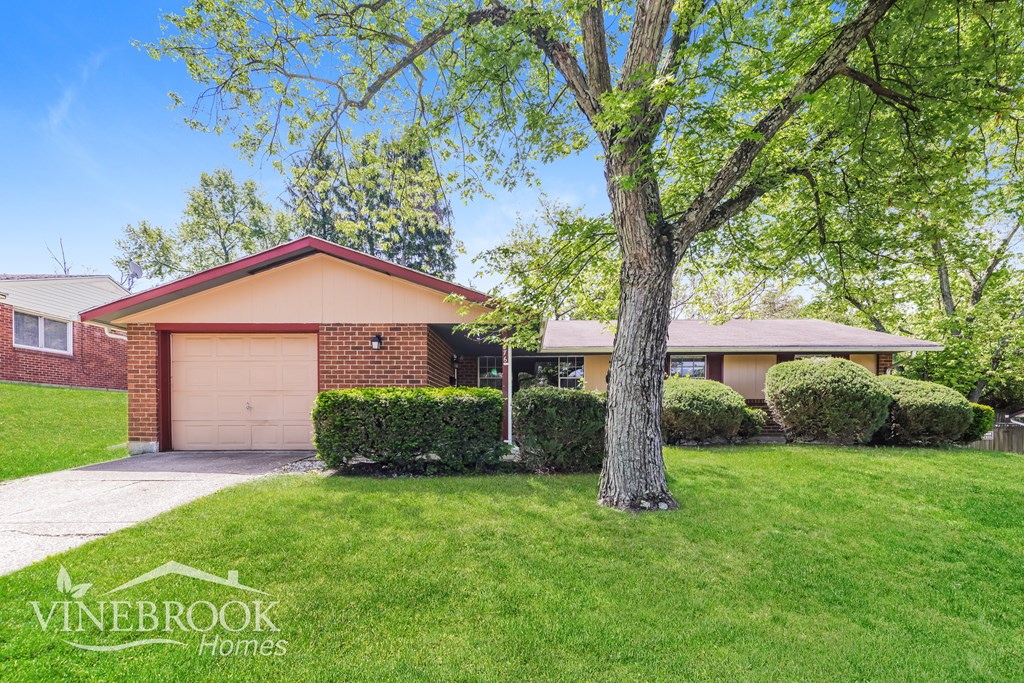 A house with a tree in front of it and the text "Vinebrook Homes" on the bottom left.