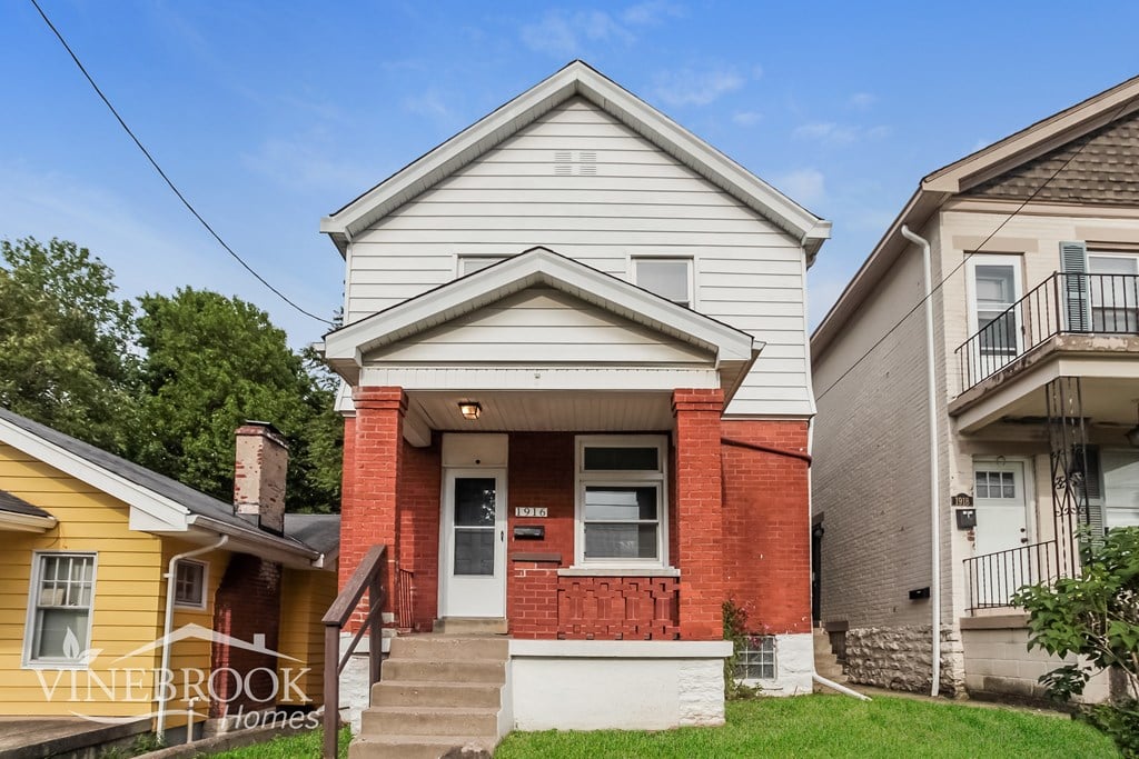 A house with a red brick front and a white porch.