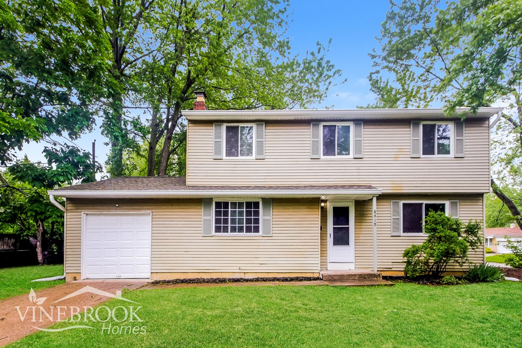 A two-story house with a garage is for sale.