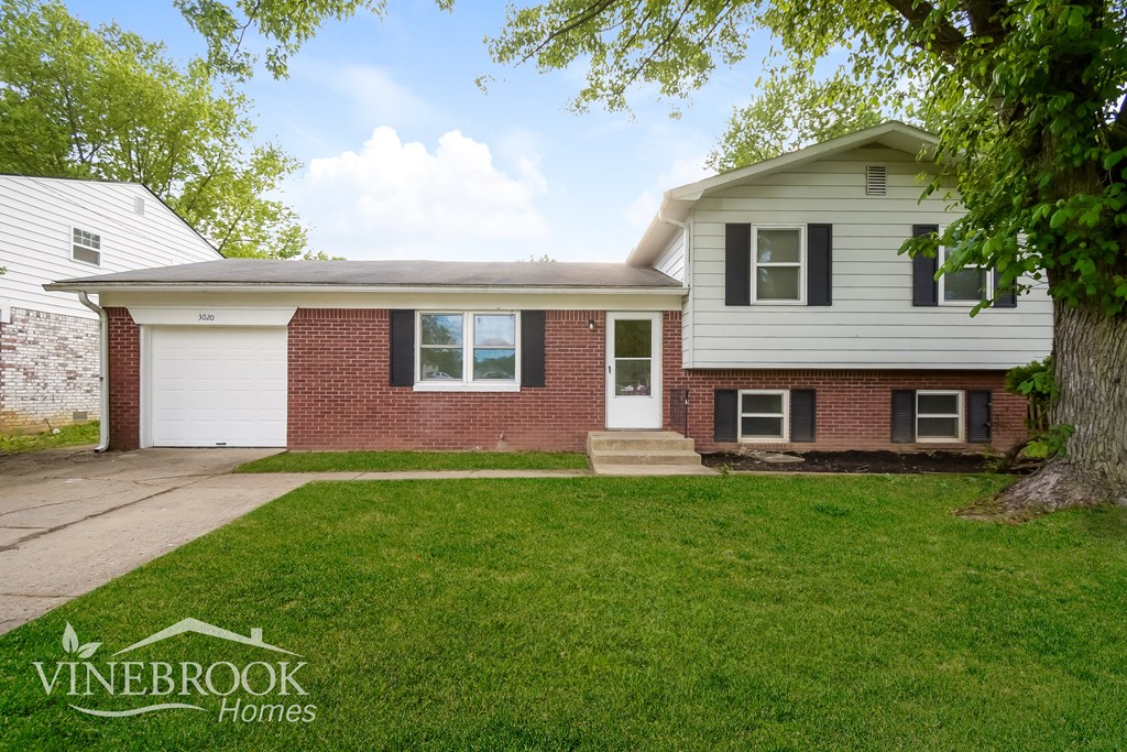 A house with a white garage door and a brick wall.