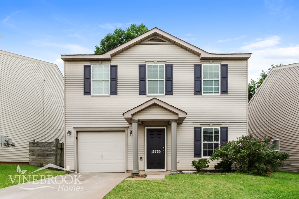 A house with a black front door and a garage door.
