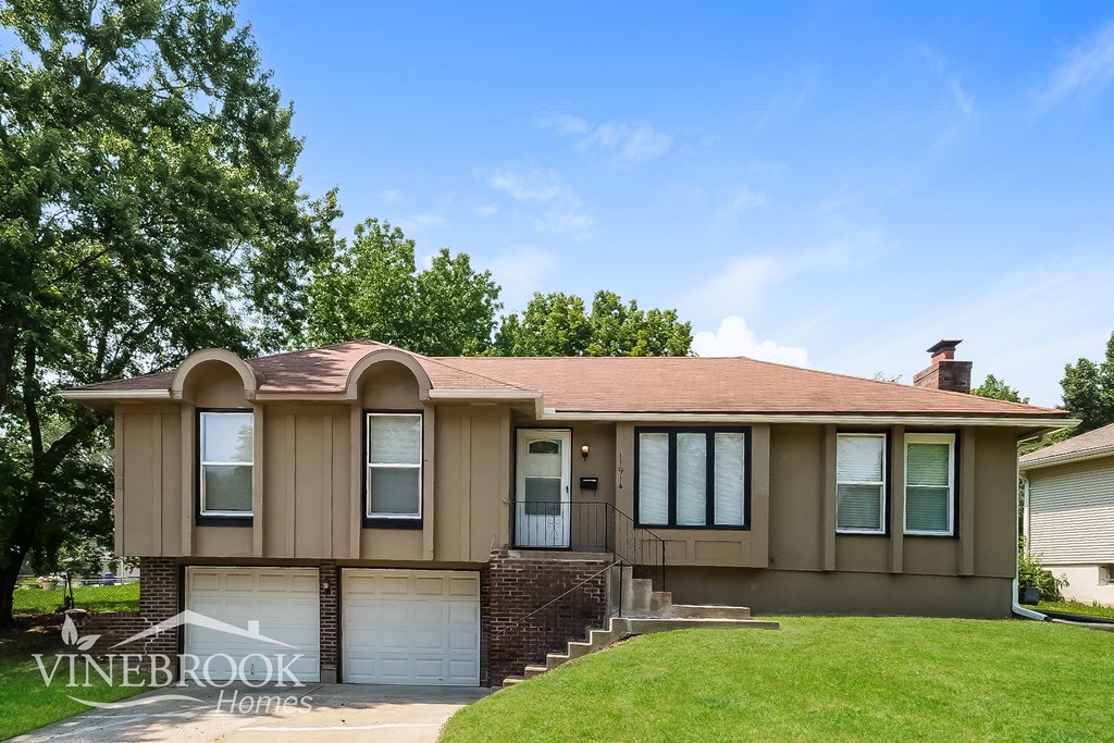 A house with a brown roof and a white garage door is for sale.