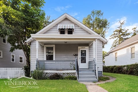 A small house with a porch and a sign that says Vinebrook Homes.