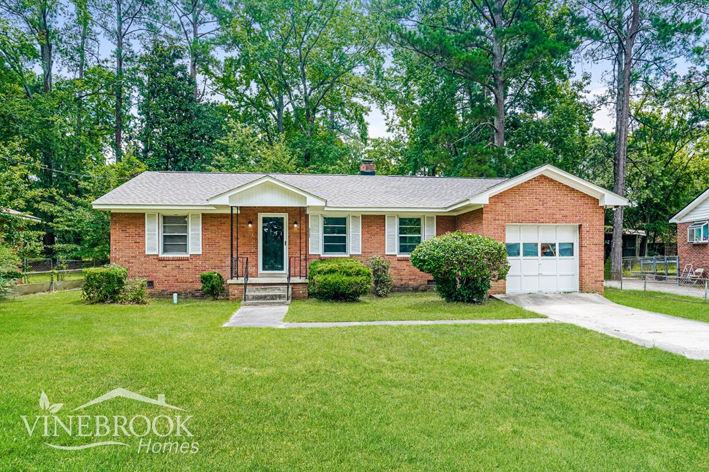 A brick house with a garage is for sale.