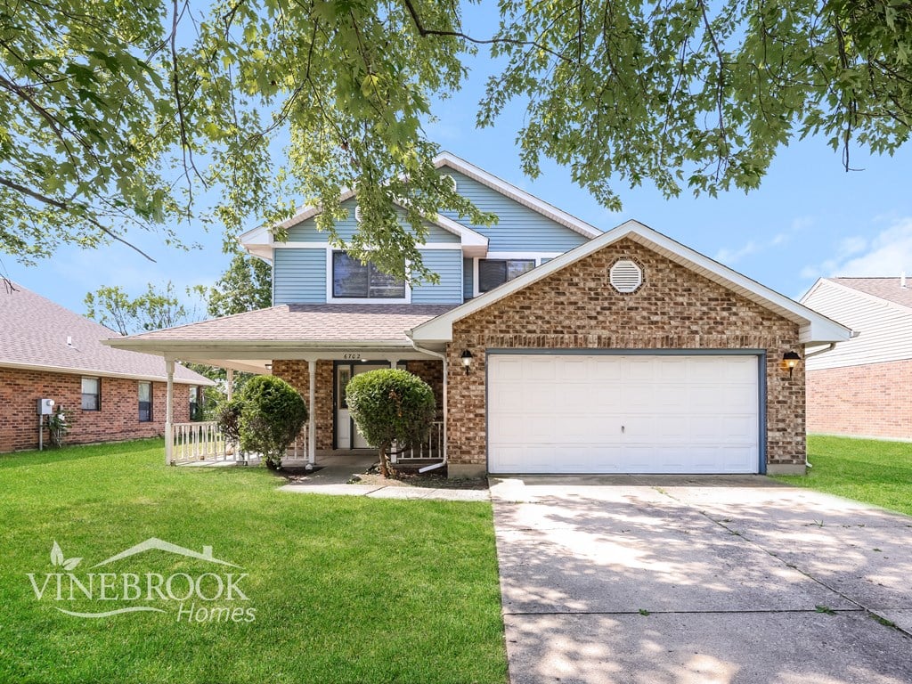 A house with a garage and a driveway is for sale.